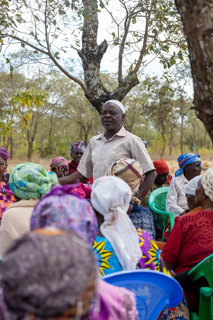 A community leader speaking to residents outdoors