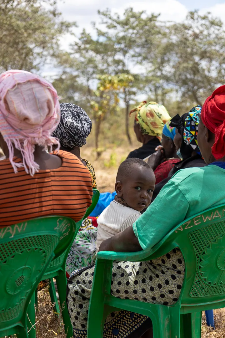 A young child attends a community gathering with family